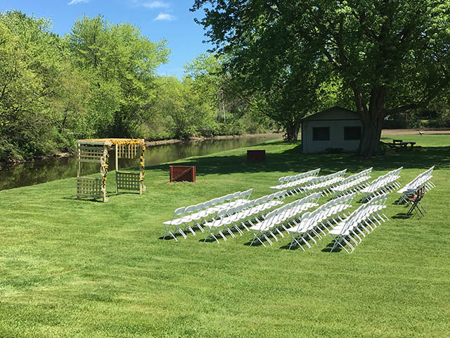 white chairs set for a wedding in the field at the barn at chestnut ridge